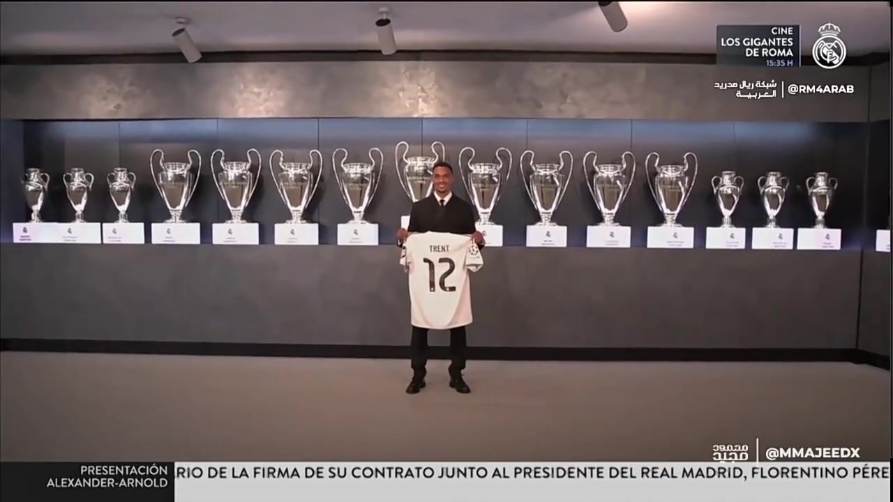 笑容满面阿诺德手举12号球衣和皇马15座欧冠奖杯合影